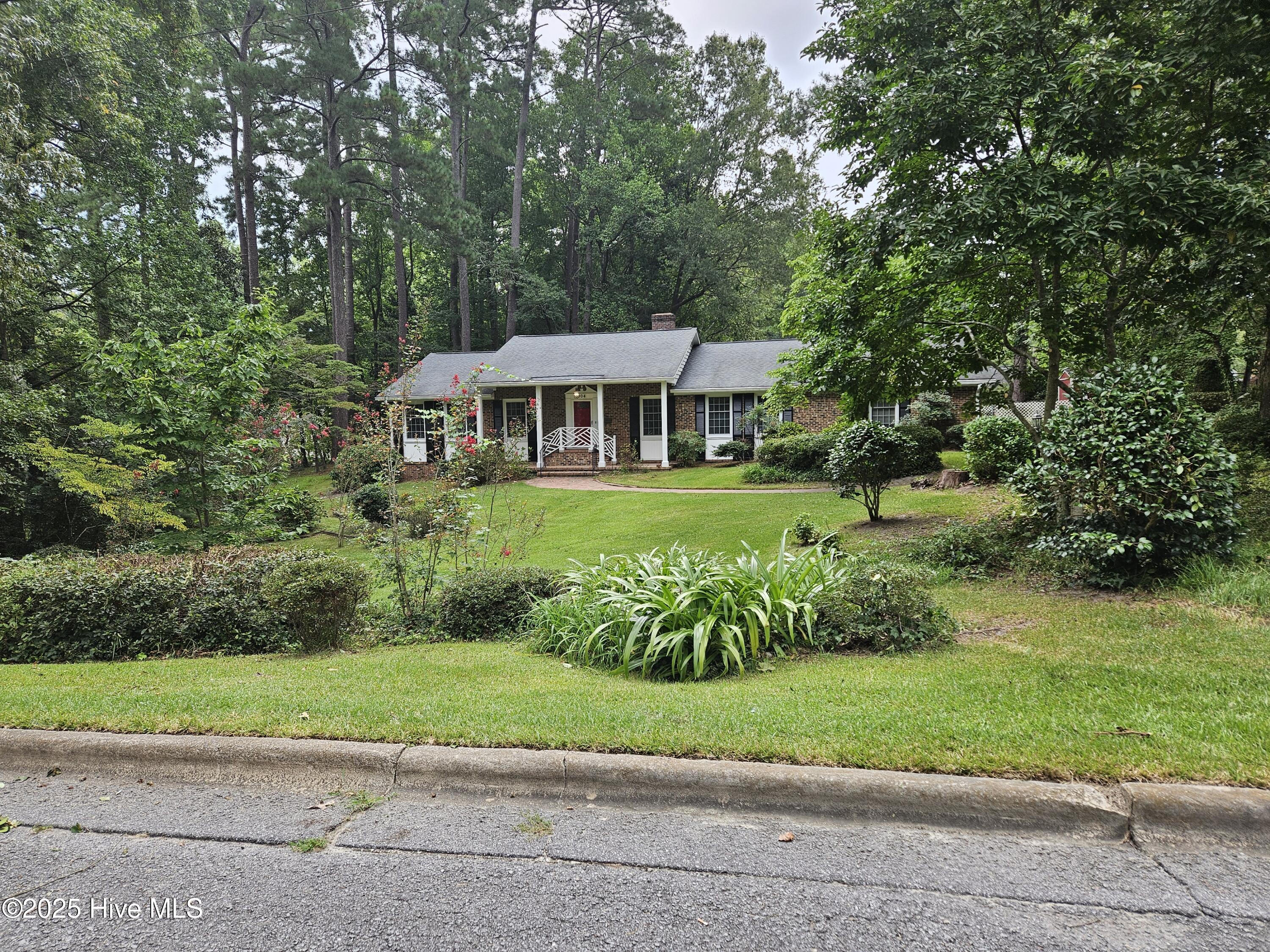 Lovely brick home nestled on deep lot in established neighborhood in Williamston. Hardwood floors in den with fireplace and formal living and dining rooms. Custom drapes in living room. 3 bedrooms, 2 full baths built-in shelving and desk in family room. Master has large walk-in closet. Kitchen has custom built revolving pantry, stove, refrigerator. Washer & dryer included. Extra refrigerator and freezer in storage room of 2 car garage. Sunroom has separate zone line hvac and a wet bar and wine cooler for 24 + bottles. Brick patio for outdoor entertaining. Fenced in back yard for your 4 legged friends. Air purifier on hvac. Natural gas and whole house Generac generator. Lot is 125 X 150, .43 acre. House is in very walkable neighborhood and is near the Roanoke River National Refuge with lots of creeks, etc. 4-5 blocks from Martin Memorial Library and Downtown post office.