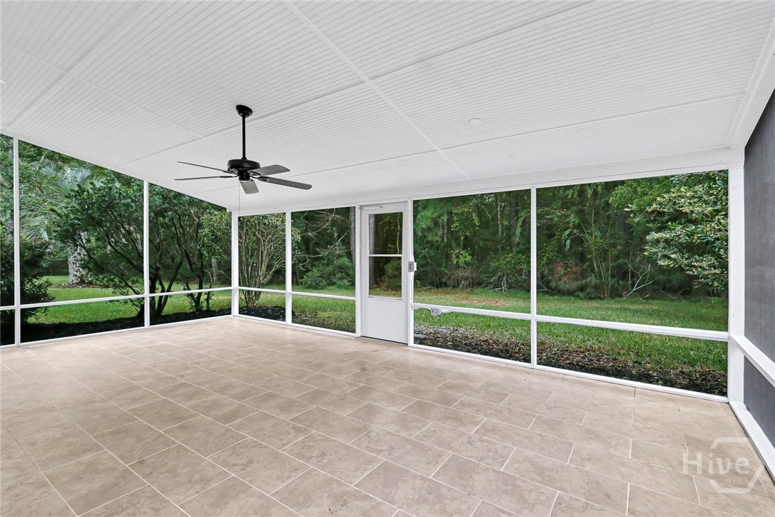 Oversized screened porch, featuring tiled flooring and views of the private wooded backyard
