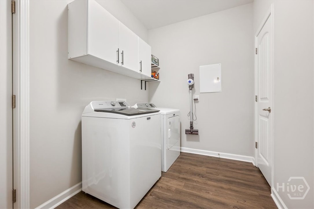 Downstairs Laundry room with cabinets and a storage closet with entrance to garage.