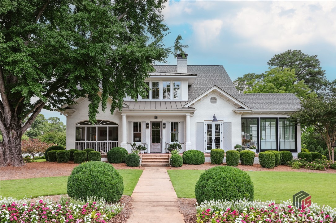 This classic brick charmer is located on University Drive, which is one of the most coveted streets in Athens. Its proximity to Five Points' many dining establishments, coffee shops, ice cream parlors and shopping provides a wonderful lifestyle, enhanced by walkability to numerous UGA athletic facilities.This classic home was fully restored in 2017 with the rear of the home being demolished, but maintaining its old world charm and curb appeal by delicately retaining the front facade and elevation. The current owners expanded the original home to provide 5 bedrooms and 6 1/2 baths. Upon entering, you are greeted by a spacious receiving room with an original gas fireplace that was salvaged during the building process. Adding to the character of this space are paneled walls and an open, split staircase that spills into both the front room and the rear living areas. To your right is a handsome study with a second gas log fireplace, a full glass door leading to a quaint rocking chair front porch, and custom built in shelving. A bright and cozy sunroom with herringbone tile floors is on the opposing side of the study and is accented by iron clad windows and a glass door leading to a spacious side yard which provides the perfect spot for a pool and spa! A smaller front screen porch is original to the home and has been updated with modern features and opens into a functional corridor leading to the heart of the home. Featuring a wet bar with marble tops, hammered sink, beverage cooler and ice maker, this service area leads you to a second office nook and powder room and into the large, open kitchen and living spaces. The gorgeous bright kitchen features marble countertops, a Wolfe 6 eye gas range with double ovens, a sub zero refrigerator and freezer, two sinks, and a reverse osmosis water filtration system. A large walk-in pantry is outfitted with a microwave/coffee station and features solid wood shelving. Located just off the kitchen, this area is complete with a second full size refrigerator. The large island overlooks both the dining space and great room, which are accented by 100 year old Hand Hewn beams in the ceiling sourced from an old school house. Providing additional character is the brick hearth fireplace in the main living space which is the perfect backdrop for evening down time and is flanked by windows and french doors leading to the larger rear screen porch.  Also located on the main level is the graciously sized primary suite which boasts two walk-in closets and two full baths, connected by an oversized tile shower.  One of the bathrooms has a beautiful soaker tub, while the other provides a linen closet, and both have their own lavatory and vanity. White oak floors span both levels of the home, as well as the stairwell. Upstairs is home to three bedrooms and three full baths, with two additional living spaces. The wide upper landing is flooded with natural light and has custom built in drawers for extra storage. This flex space is large enough to be a second den or upper level office. An oversized bonus room with vaulted ceilings could easily be converted to a fourth bedroom with the installation of a door, but it currently serves as a game room. All upper level bathrooms feature walk-in showers with frameless glass doors.Providing private guest quarters is the carriage house above the garage. Accessed from a covered, exterior stairwell the carriage house is very spacious with a perfect nook for a kitchenette if one so desires. The large full bath has a walk-in shower and an antique sink with double faucets. A private rear driveway leads to the two car garage and third parking pad, and offers a great area for a basketball goal.No stone has been left unturned in this gorgeous renovation, and it is one of the most admired homes in Athens with its breathtaking ginkgo tree in the front yard.