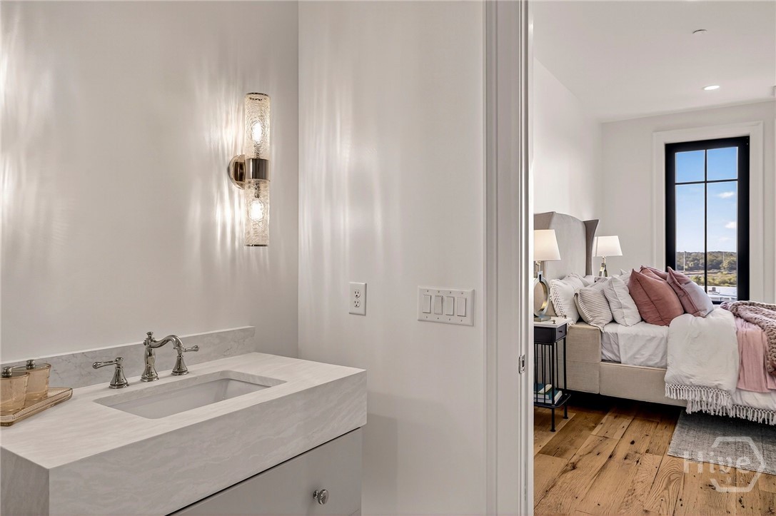 Bedroom 2 Ensuite - A marble-topped vanity anchors the ensuite’s entry, offering a seamless transition between bedroom and bath. Warm lighting and traditional fixtures enhance the space’s elegance, while the open doorway maintains visual continuity. A cohesive suite layout that blends privacy with architectural charm.
