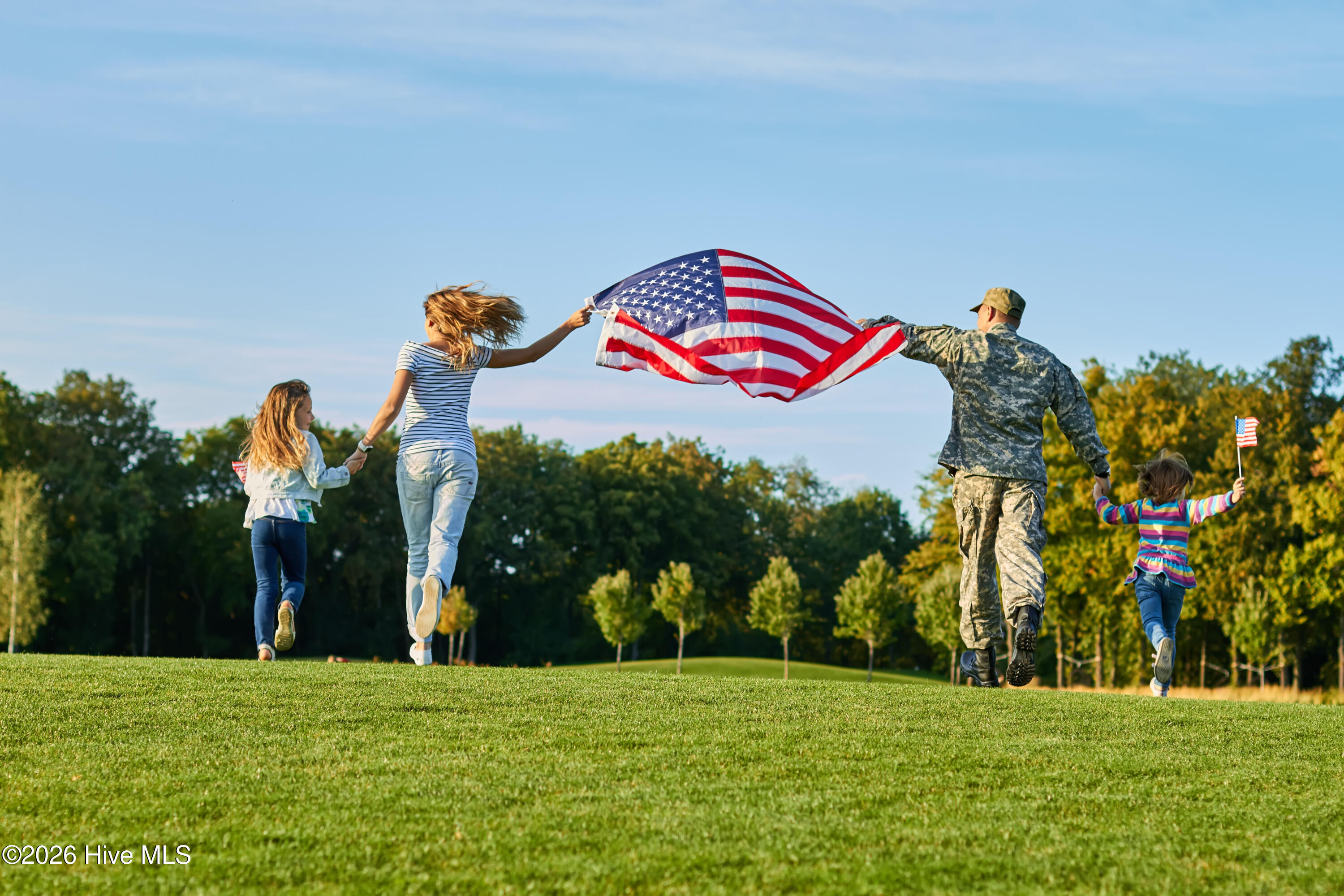 Military Family Walking in Field Holding