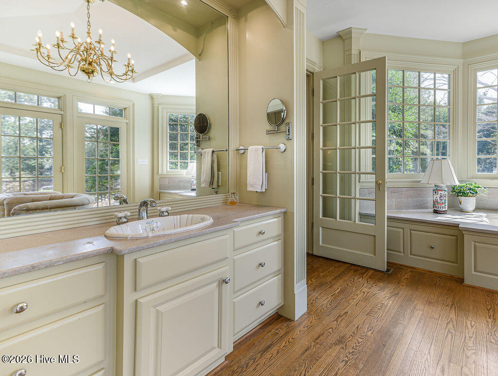 Finished with marble counters, a Jacuzzi tub, stone-tile walk-in shower with dual rain heads, chandelier, and French doors to the grounds, the bath is both elegant and serene.