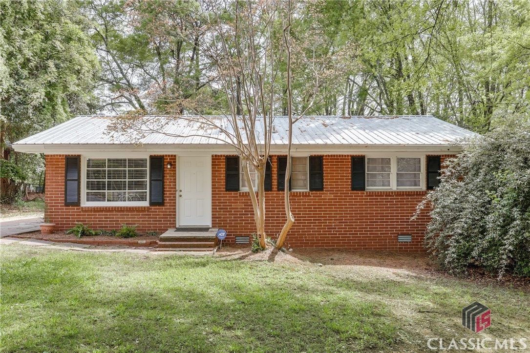 Welcome to this beautifully updated 3-bedroom, 2-bathroom brick ranch in the heart of Knottingham—a neighborhood known for its charm and unbeatable convenience. This move-in-ready home features hardwood floors throughout and is filled with natural light that highlights every thoughtfully renovated space. Step inside to a spacious den with stunning picture windows that flood the space with light and offer a lovely view of the front yard. The kitchen features freshly painted cabinetry, updated hardware, and a stylish new backsplash—creating a warm and functional space for cooking and gathering. The primary suite offers a brand-new private bathroom addition, while the two additional bedrooms share a generously sized hall bath. Every detail has been lovingly maintained.  Recent updates provide modern peace of mind, including fresh interior paint, a durable new metal roof, brand-new HVAC and heat pump, updated electrical service, and all-new plumbing to the house. Out back, enjoy a large, flat, and private yard with plenty of sunlight—ideal for relaxing, gardening, or entertaining. Just minutes from Normaltown, downtown Athens, UGA, local restaurants, and more, this home delivers on location, style, and value. Don’t miss this rare opportunity in Knottingham—schedule your showing today!