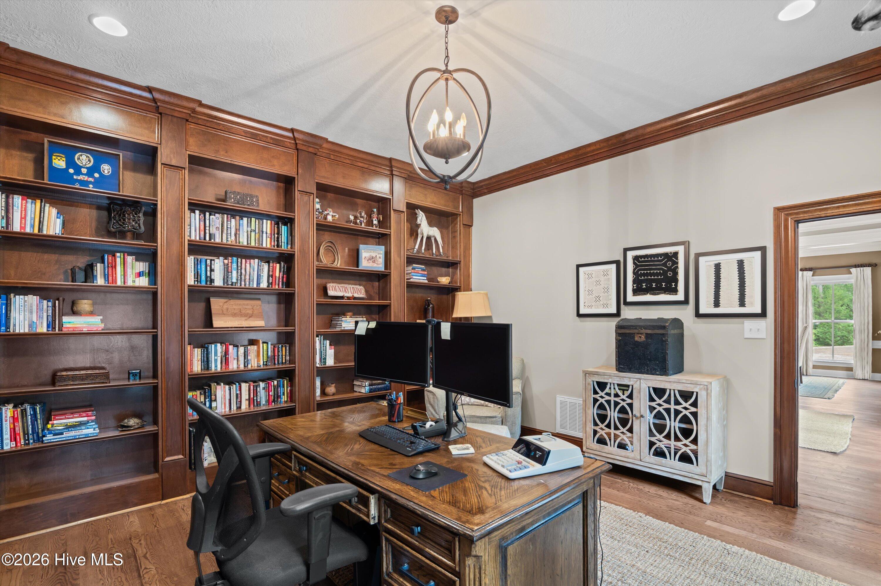 Office with floor to ceiling wood bookshelves
