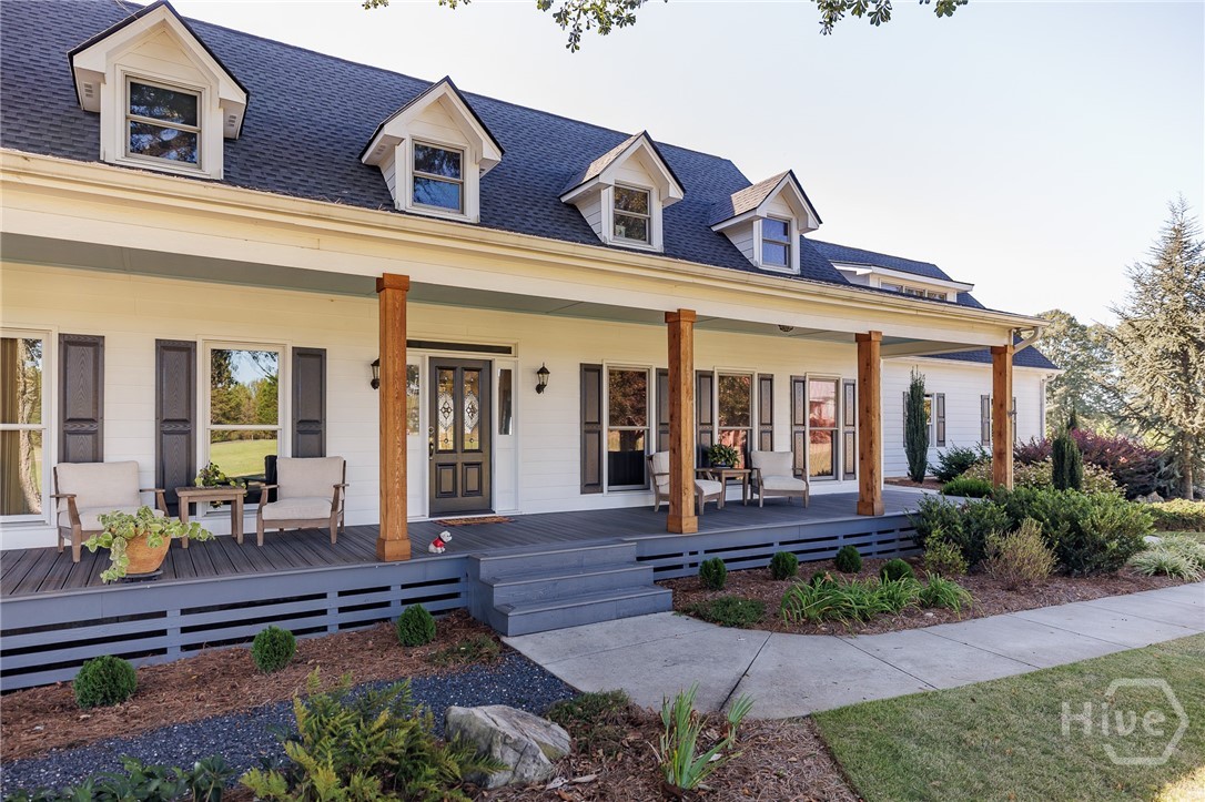 Some homes are best defined by how they make you feel, and here, it starts on the front porch. Stretching across the front of the home, this expansive porch is designed to be lived on. With a porch swing, multiple seating areas, and views over beautiful open pasture, this is the kind of space where mornings begin slowly and evenings end out back by the pool, watching the sun set over the surrounding acreage. Inside the front door, a wide and welcoming foyer sets the tone. To one side, a main-level bedroom and full bath offer flexibility for guests or everyday convenience. To the other, a spacious living room centered around a fireplace creates a warm and inviting place to gather, with large windows overlooking the pool and pasture beyond and direct access to a screened porch along the side of the home. A cozy keeping room provides an additional sitting area, creating a natural and comfortable transition into the kitchen, the true heart of this home. Featuring custom cabinetry, a spacious place to prepare meals, and an oversized island to gather around, the kitchen is functional and well-appointed. A large laundry room/ mud room with custom cabinetry and lots of storage creates the perfect space for staying clean and organized in this home.  Opening seamlessly into a sunlit dining room framed by a wall of windows, from the kitchen you’ll capture sweeping views of the backyard, pool, and surrounding acreage. The outdoor landscapes, the pond views and the open acreage are truly compelling. The pool is set within thoughtfully designed landscaping and stamped concrete, complemented by a powered awning that extends the usability and comfort of the backyard space. A brand new vinyl liner ensures it’s ready to enjoy, while the surrounding 8.644 acres of open pasture create a backdrop that is both expansive and peaceful. An irrigation system, fed by a private well, supports the landscaping and sod with ease. Upstairs, the layout offers a level of flexibility that adapts to a variety of needs. The primary suite is privately positioned and includes a large walk-in closet with custom systems and a well-appointed bathroom with tiled shower and separate soaking tub. There is a large secondary bedroom with an ensuite bathroom that connects an adjoining room, ideal for a library, office or cozy den. The upstairs layout provides opportunities for private suites with adjoined dens, and a secondary stairwell provides separate access from the garage, further enhancing the functionality and access of this space — ideal for an in-law suite or secondary independent suite. The finished basement continues that theme of versatility, offering a large den, spacious kitchenette with ice maker, and a full bathroom, perfect for gathering and entertaining.  An unfinished workshop area with exterior access, perfect for hobbies, storage, or projects finishes out the basement space. Thoughtfully upgraded with efficiency in mind, the property includes a 32-panel solar array paired with two Tesla backup batteries, delivering both sustainability and performance, with current owners reporting power bills averaging only $40–$50 per month. A whole home Generac generator provides added peace of mind for self-sufficiency. From the front porch to the kitchen views to the backyard setting, this home offers a lifestyle centered around space, flexibility, and connection to the beautiful, green pastures and wide open spaces.