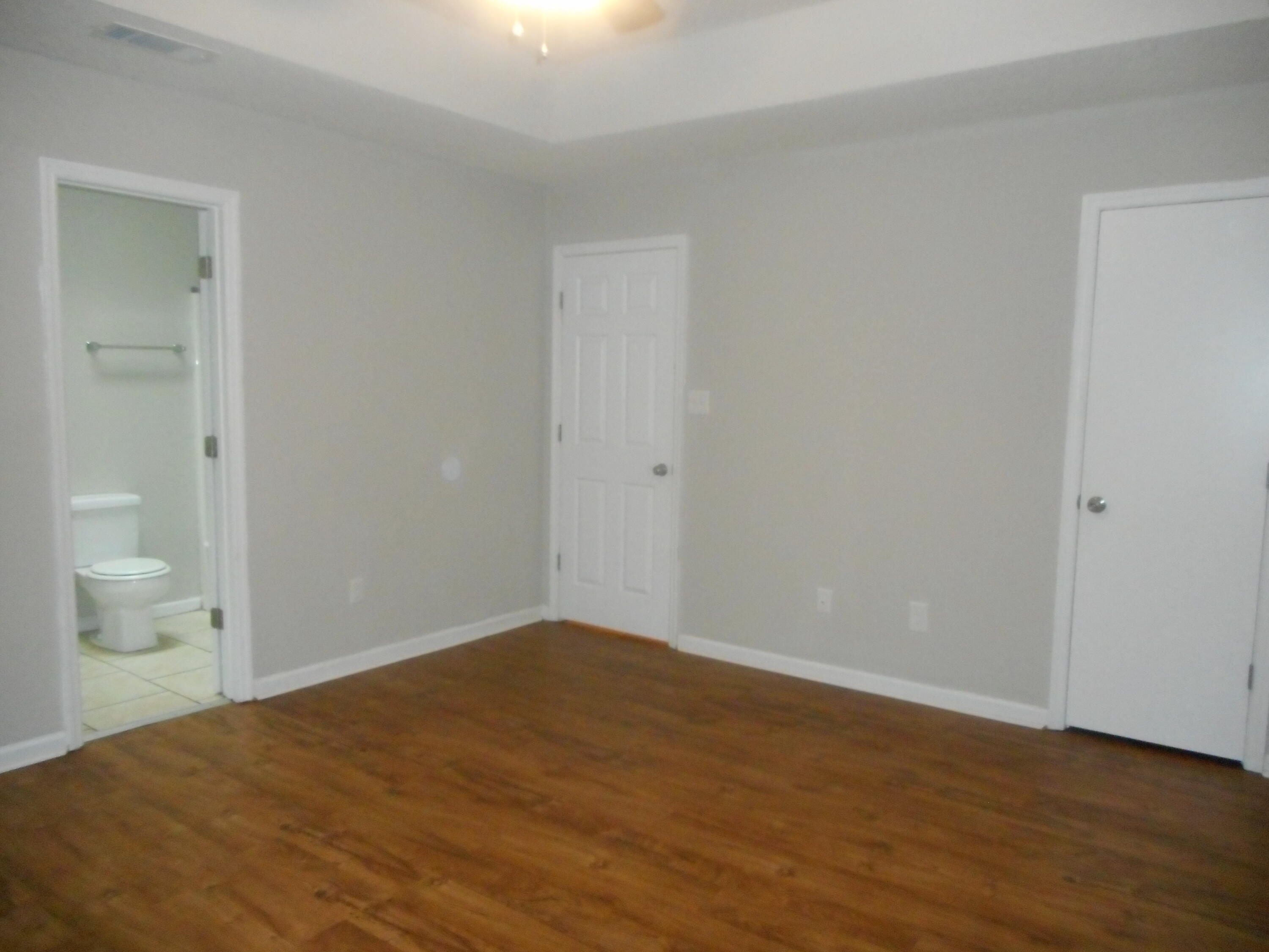Owner suite with walk-in closet, ceiling fan and private bath.