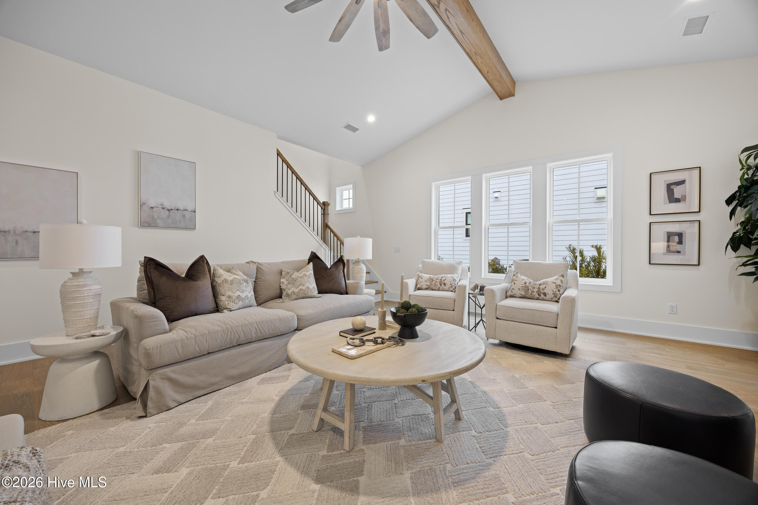 Living room with vaulted ceilings, custom built-ins, and a natural gas fire place