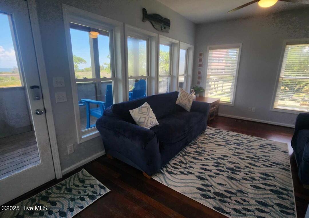 Lower level living room with access to deck and screened in porch and 2 primary bedrooms