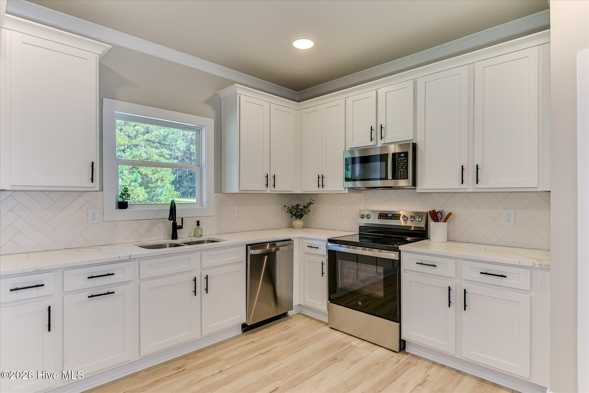 Well-equipped kitchen with quartz countertops, stainless steel appliances, and pantry
