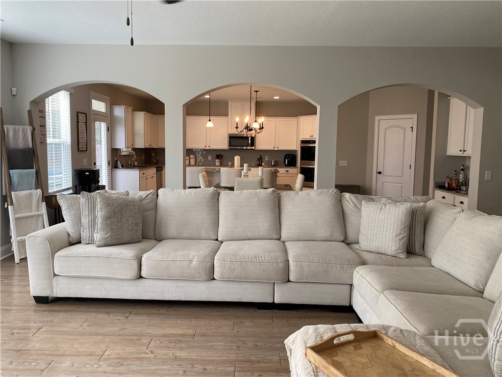 Living room showcasing arched opening with still o