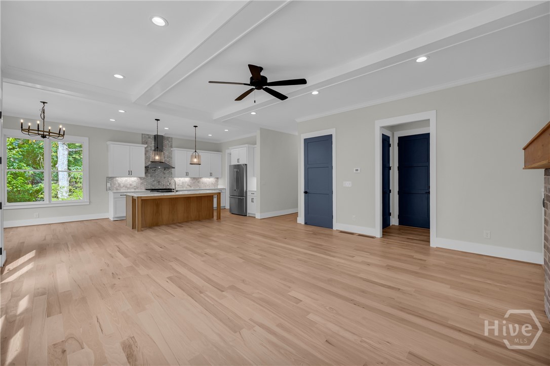 Spacious interior featuring wood-finish flooring, a tray ceiling, and recessed lighting
