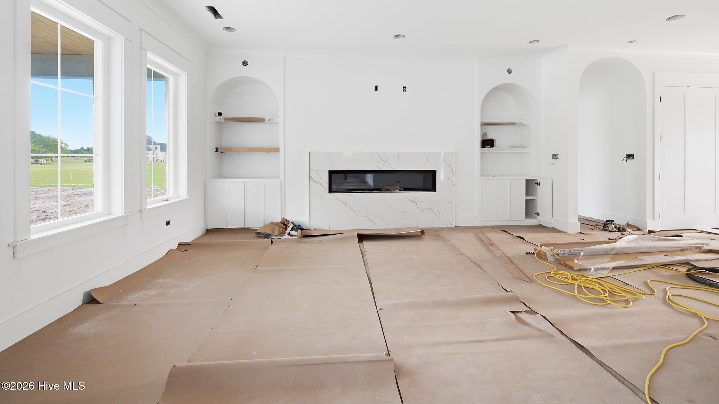 living is repeating the arches and draws the eye to the 7 foot linear fireplace flanked with custom book cases