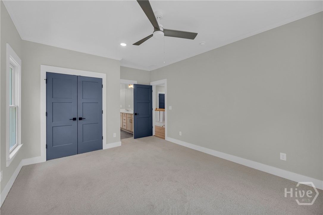 Carpeted room featuring a ceiling fan, recessed lighting, and a window