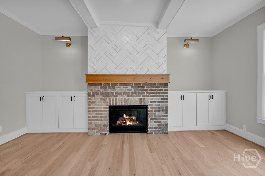 Fireplace featuring a brick surround, wood mantel, and herringbone accent