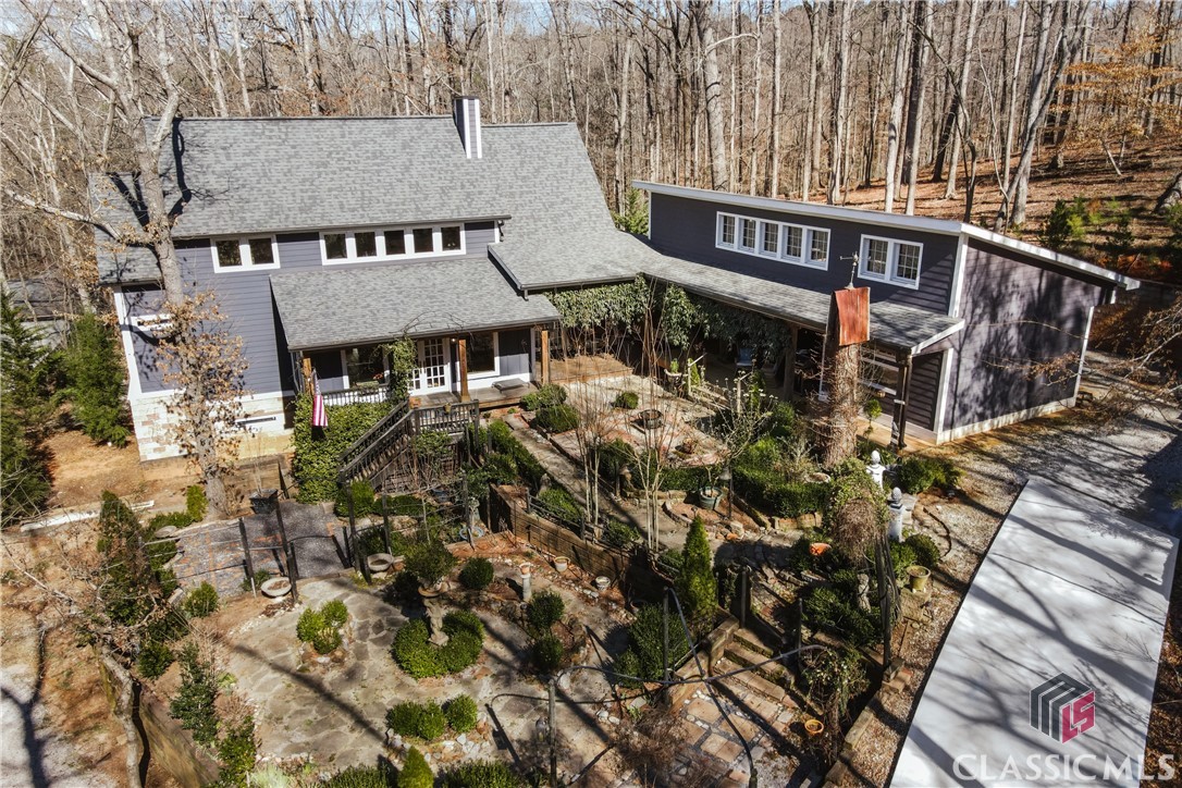 555 Somerset is a masterfully crafted sanctuary nestled on a coveted double lot in the heart of Athens. Artisan built in 2017, surrounded by nature yet minutes from everything, this one-of-a-kind residence offers an unparalleled living experience that simply cannot be replicated.When you walk in the front door, you will need a minute to soak it all in amid grand vaulted ceilings, custom woodwork, and abundant natural light . Situated on a very private double wooded lot with water and wooded views, you'll feel like you are worlds away from it all, yet you are located in one of the most convenient locations in all of Athens with ease and proximity to shopping, dining, the loop 10, and all schools - zoned for Timothy Road and the new Clarke Middle, and also very close to Athens Academy. The house is built centered around beautiful gardens, which also provide maximal privacy. The front door foyer entry way opens to a grand but very comfortable living and dining space with 28' ceilings. The beautiful woodwork through the house has been reclaimed from the property itself combined with the artist's repurposing of old wood reclaimed from a church. Perfectly placed end cuts in the foyer gives way to hand hewn oak wood flooring throughout the rest of the home. Wood walls, beams, and live edged accents create a beautiful and warm great room. The kitchen was just recently and thoughtfully redone with custom cabinetry and thoughtfully placed storage features, quartz countertops, high end KitchenAid appliances, a great pantry, and huge cathedral windows that overlook natural areas. The living room has a beautiful fireplace and open staircase with custom iron railing, high ceilings, and stunning woodwork. The owner's suite is on the main level with French doors to the gardens, cozy wooden walls, a study / nursery / office and beautiful bathroom with custom touches and large closet. Upstairs are two generously sized bedrooms with good closet space and a great hall bath that was recently updated. The natural light pours into all of the rooms. The long and winding driveway goes completely around the entire house for ease of entry and exit and offers plenty of parking for guests. A 960 sq. ft. covered multi-use pavilion is wired and plumbed for outdoor entertaining, and can also be used as covered parking. The double lot offers the ability to construct a second residence (please inquire for more detail). Additionally, there is a basement apartment that is currently leased - offering an income producing dwelling and / or an opportunity for multi-generational living with designated parking and easy private entrance. Separate from the private studio apartment, a large unfinished basement space provides more storage.This spectacular property is simply like none other - no detail was forgotten. It’s simply not to be missed.