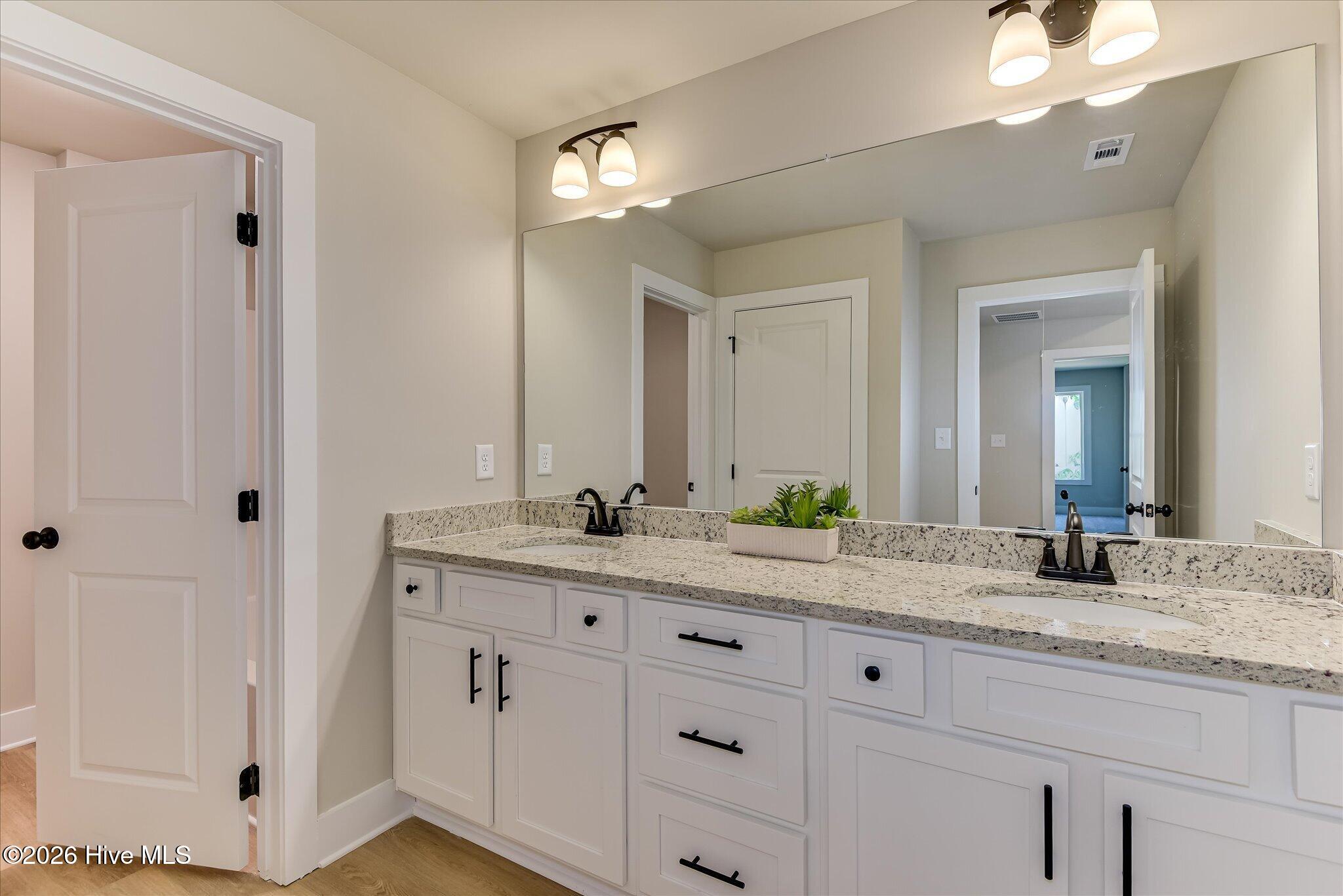 Large, full bathroom with granite countertop, double-sink vanity, tub/shower combo is upstairs.
