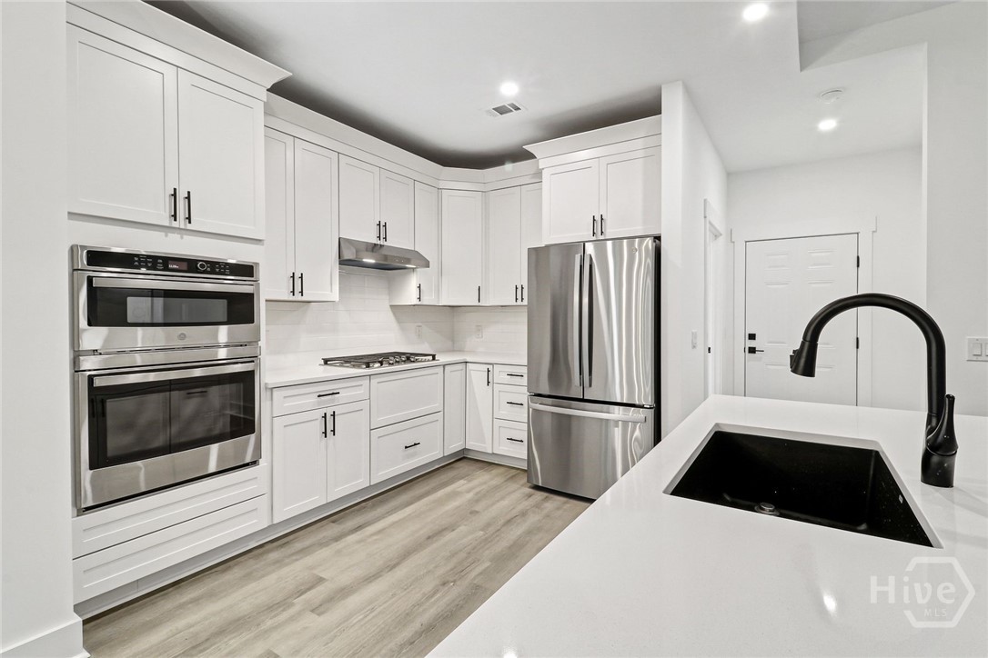 The gourmet kitchen includes a gas cooktop, microwave/double oven combination, soft-close cabinetry, quartz counter tops.
