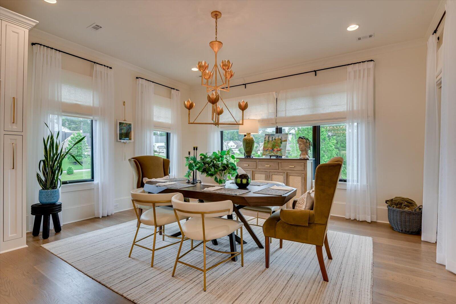Breakfast room with white oak flooring with surrounding windows.