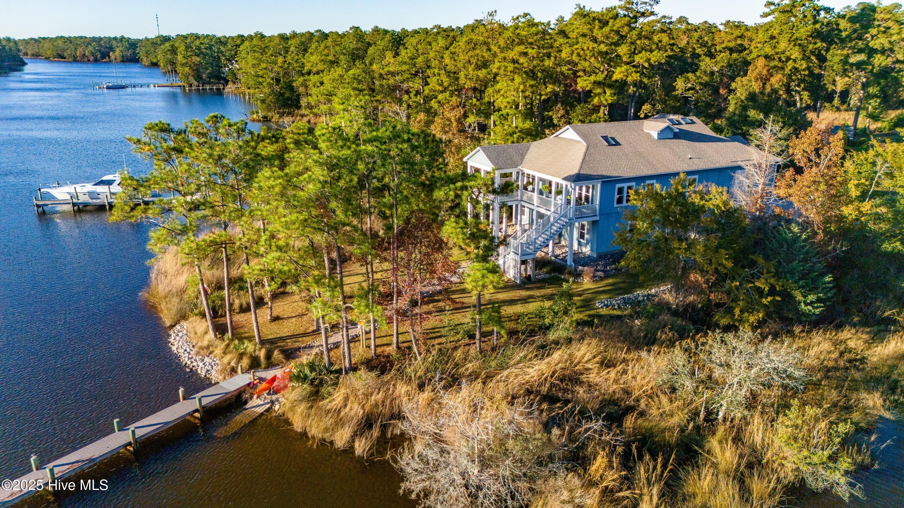 This spectacular 4-bedroom, 3-bath waterfront home overlooks deep-water Kershaw Creek and includes a private pier, boat dock, and lift—ideal for seamless access to the Pamlico Sound. Built on an exceptionally strong precast concrete foundation with a raised-slab elevation, the home offers remarkable structural integrity, energy efficiency, and long-term durability.Inside, the open-concept living area features high ceilings, abundant natural light, and generous spaces designed for both comfortable living and elegant entertaining. The great room is anchored by an upgraded stone fireplace with a custom sinker cypress mantle, creating a warm and distinctive focal point.The lower level includes a beautifully finished 1,244 sq. ft. guest apartment with a private entrance. This inviting space offers its own living room, kitchenette, full bath, one of the home's four bedrooms, and a spacious den or office—providing exceptional flexibility for extended family, guests, or private work quarters.Additional enhancements include a new Trane HVAC system installed in 2024, gas logs for cozy and efficient warmth, an elevator, tiled floors, a Kinetico water softener, Rinnai tankless water heater, Trex decking, generous garage and storage areas, and a climate-controlled attic.The exterior has been thoughtfully upgraded with PVC plank cladding, ensuring superior durability and minimal maintenance—an ideal advantage in a coastal environment. A spacious covered deck offers year-round enjoyment of the serene waterfront setting and the home's desirable southwestern exposure.Located just ten minutes from the village of Oriental and a short boat ride to the Pamlico Sound, this home combines waterfront tranquility with exceptional coastal convenience.
