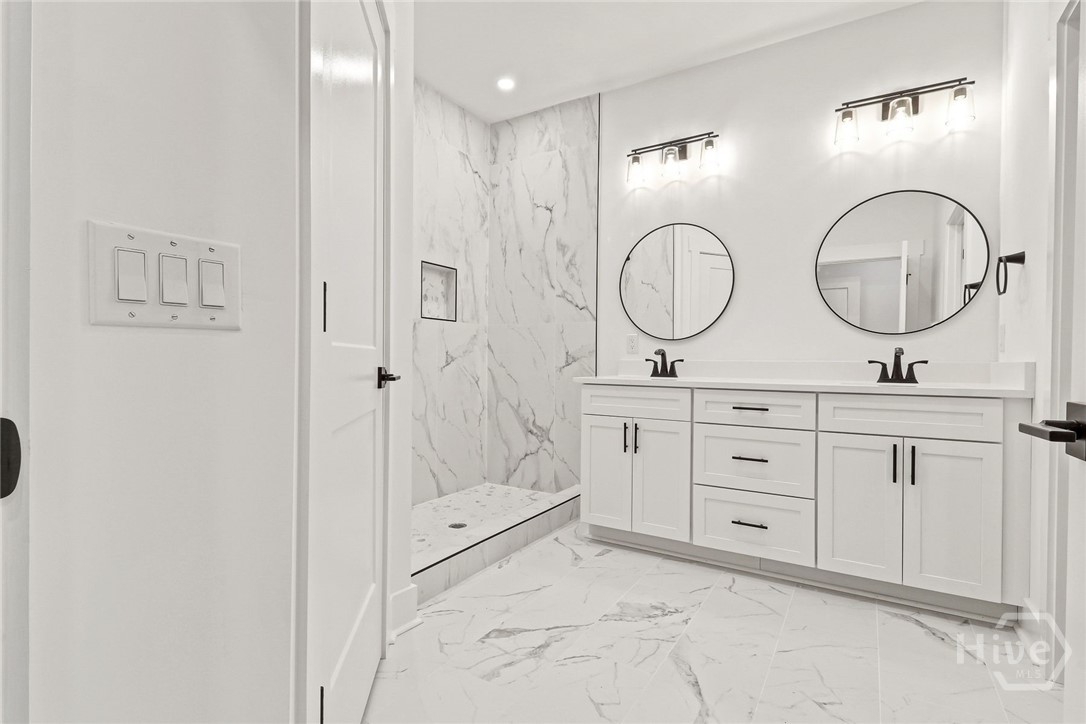 Primary bathroom with double vanities and shower.