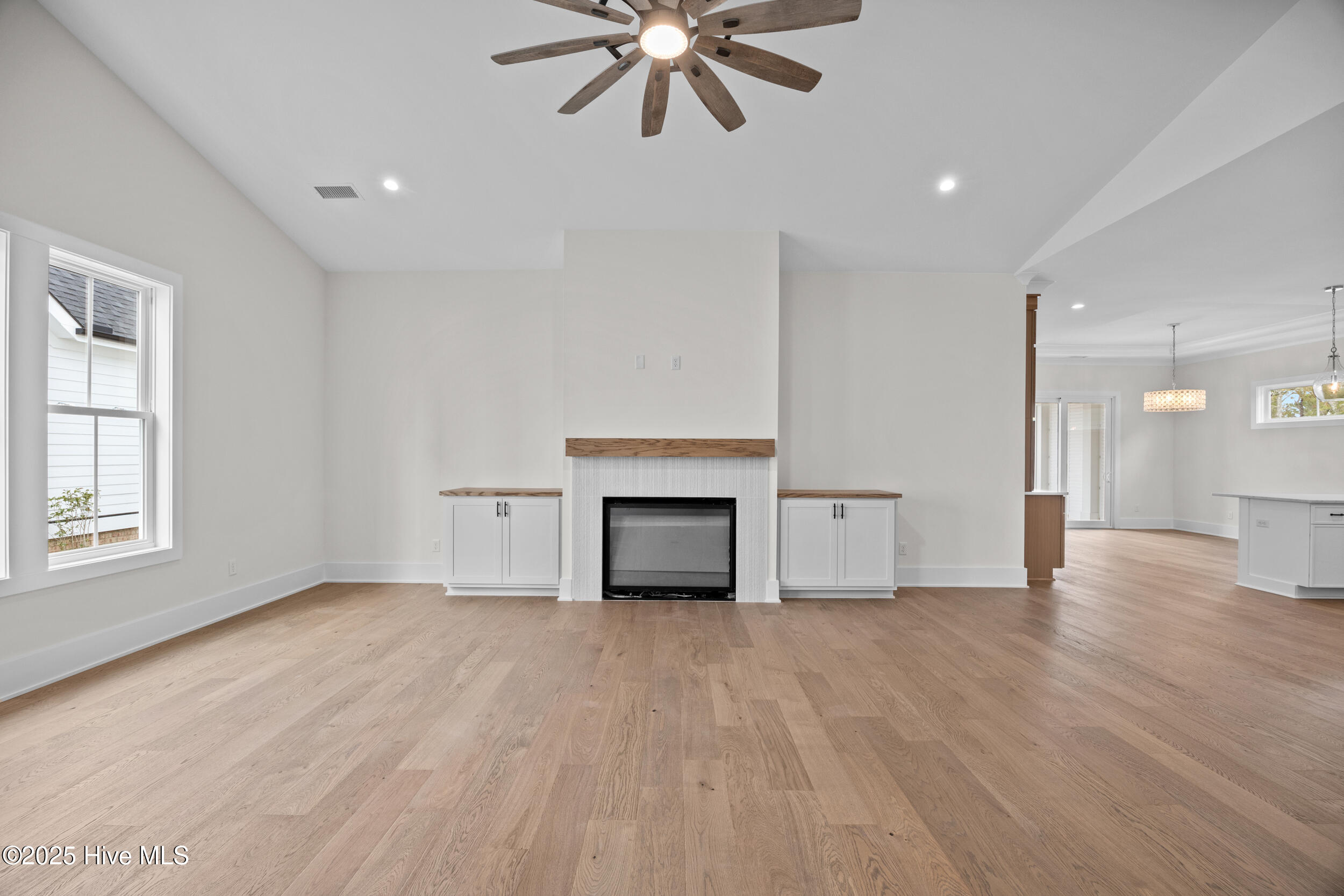 Living room with vaulted ceilings, custom built-ins, and a natural gas fire place