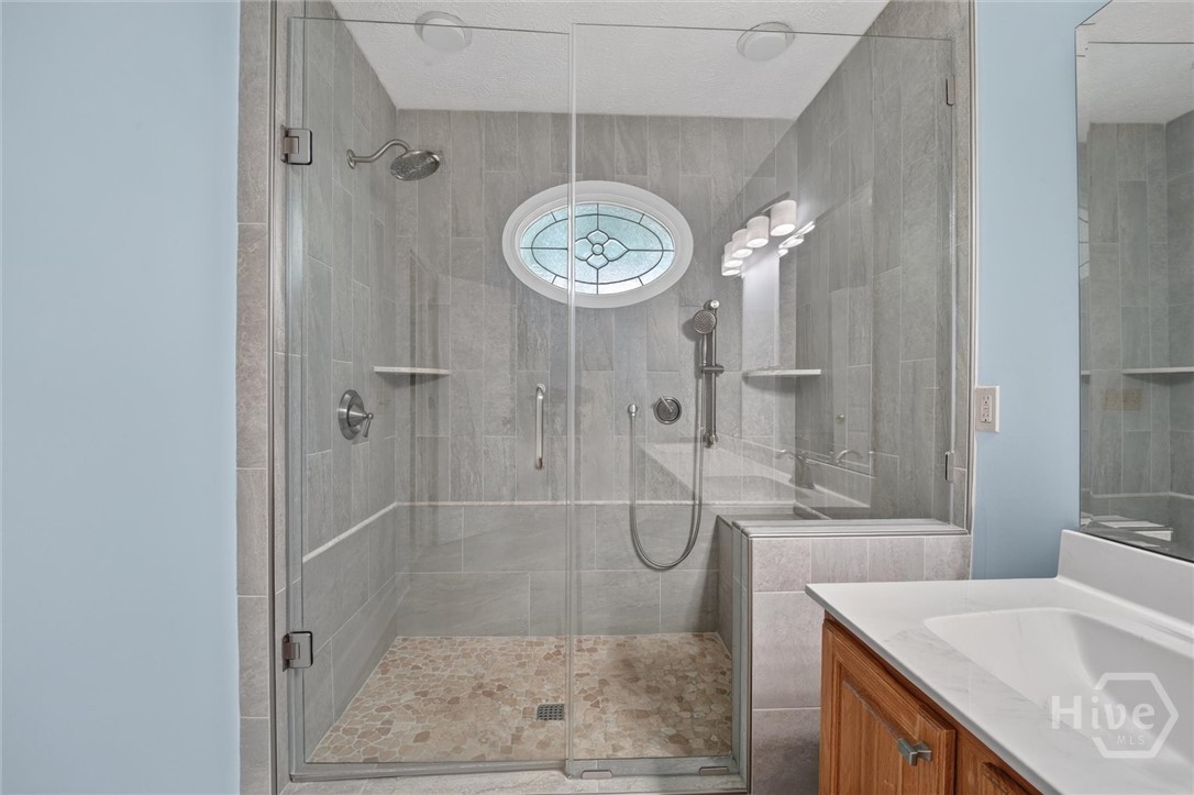 Primary suite bathroom with walk in tiled shower