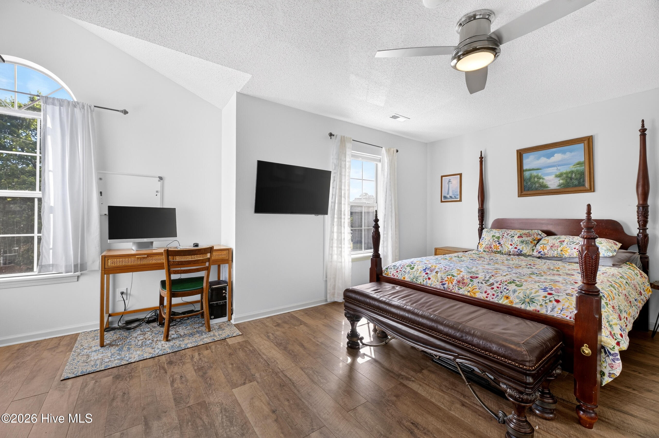 Primary bedroom offers natural light and space for work station