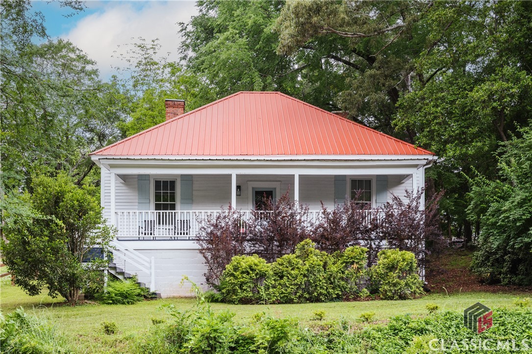 Welcome to 2142 South Lumpkin Street, a 1930 Craftsman cottage tucked away in 5-Points. This home is situated between Lumpkin Street and Old Princeton Road,providing an excellent location that still feels private. The 1600 square feet and multipleoutdoor living spaces are absolutely filled with character, with fun and intricatearchitectural details around every corner.As you step inside, you'll be greeted by the warmth of heart pine floors, high beadboardceilings, built-in cupboards, beautiful chandeliers and handpainted artwork adorningwalls. Multiple period-style fireplaces add to the home's historic allure, creating cozyfocal points throughout. Even the foyer is charming and includes a built-in desk areathat is flooded with natural light.The recently remodeled bathroom features black and white floor tile, tile wainscotting onthe walls, and a beautiful clawfoot tub/shower. The bath is both an ensuite andaccessible from the foyer. The kitchen is both cute and functional, with new appliancesand floating shelves added in 2022, and it leads to the convenient laundry room withincluded pantry storage.The floor plan unfolds in a manner consistent with many homes of this era, with a largecentral hallway and two rooms on either side. Two large bedrooms, including a primarysuite, are located on the right side of the hall, while the left includes a spacious livingroom and huge dining room.One of the unique features of this home is its seamless blend of indoor and outdoorliving spaces. A covered front porch overlooks Lumpkin Street, while the back entranceoff Old Princeton Road leads to a private oasis complete with a large wooden deck,terraced garden area, painted mural and stone path, providing the perfect setting foroutdoor dining and relaxation.The home isn't just about aesthetics; it's also move-in ready with updated infrastructure.A recently pressure-washed metal roof is in great condition, new gutters were installedin 2022, a Trane heat pump HVAC system was installed in December 2023 with a Wifi-enabled thermostat, the entire inside and wood-sided exterior were recently painted,and a current termite bond ensure peace of mind for years to come.Location is prime with the back entrance to Memorial Park right down the sidewalk, thecenter of 5 Points a mile away, South Campus of UGA just 1.5 miles, and BeechwoodShopping less than 2 miles away. Don't miss your chance to make 2142 South LumpkinStreet your own little piece of history!