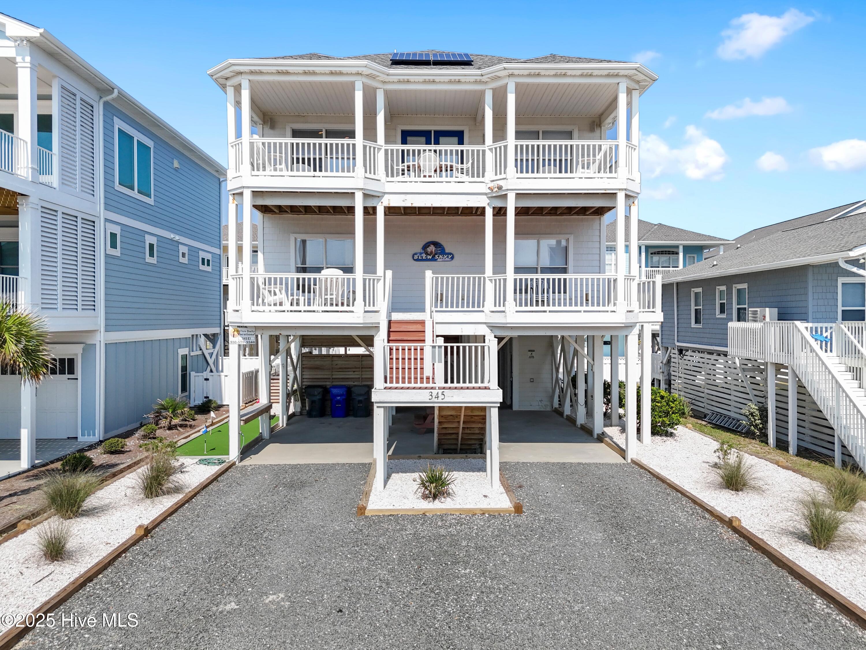 345 E First Street Ocean Isle Beach, North Carolina Experience elevated coastal living in this fully furnished, resort-style beach retreat. Impeccably maintained and thoughtfully designed, this 5-bedroom, 5.5-bath residence combines timeless elegance with modern comfort. This home is just 400 feet away from the Greensboro Street beach access, providing quick and easy beach access.
A reverse floor plan showcases sweeping ocean views, with an elevator providing access to every level. The top floor also features a versatile bonus room, ideal for use as a home office or media lounge. The soaring ceilings in the kitchen and living areas create a bright, open, and airy feel, perfect for both relaxation and entertainment.
The outdoor living spaces are nothing short of spectacular. A private pool anchors the backyard oasis, complemented by a custom tiki bar and professional-grade putting green with low-maintenance turf. Every detail has been curated for the ultimate coastal lifestyle.
This home is also a testament to modern sustainability, with a fortified roof with solar panels that cut energy costs by more than half. With an amazing rental history and accommodations for up to 18 guests, this property is an exceptional investment opportunity. An assumable low-rate flood insurance policy adds even more value.
Discover the perfect balance of luxury, relaxation, and opportunity in this extraordinary island retreat.