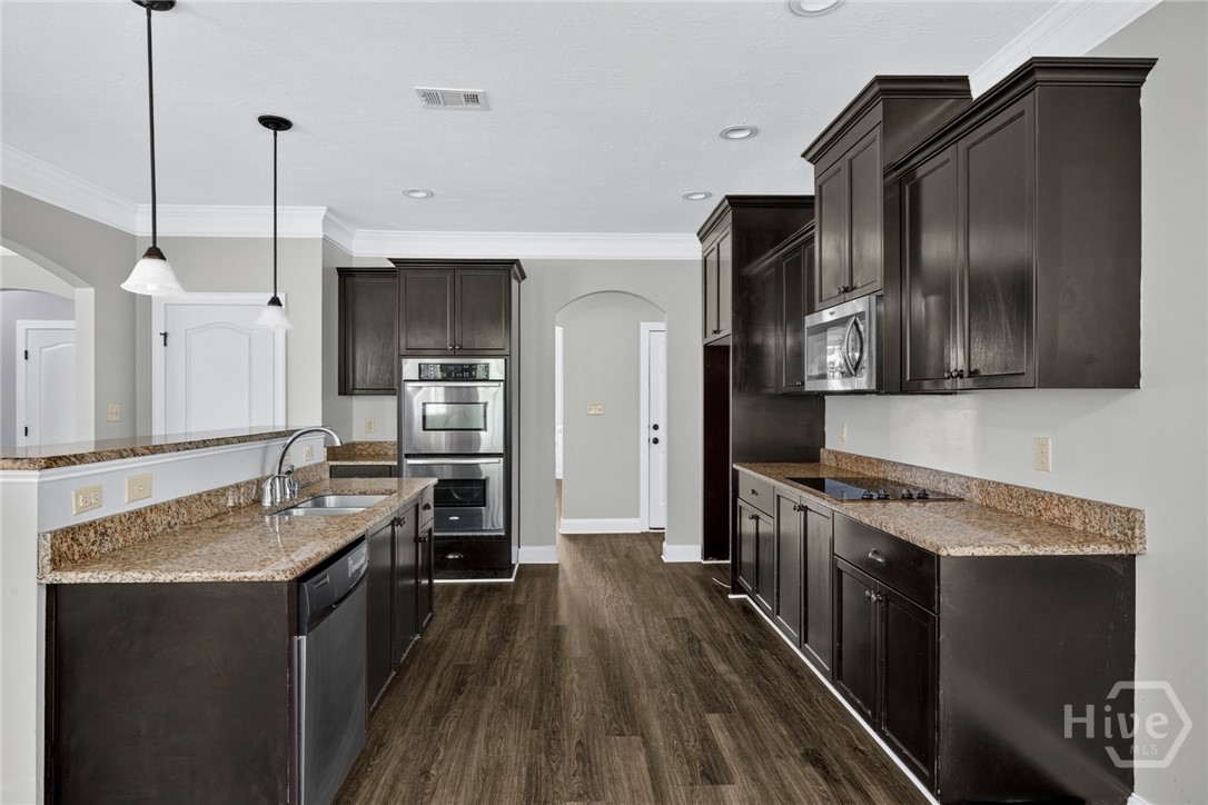 Dark wood cabinetry, granite countertops, double oven and pantry
