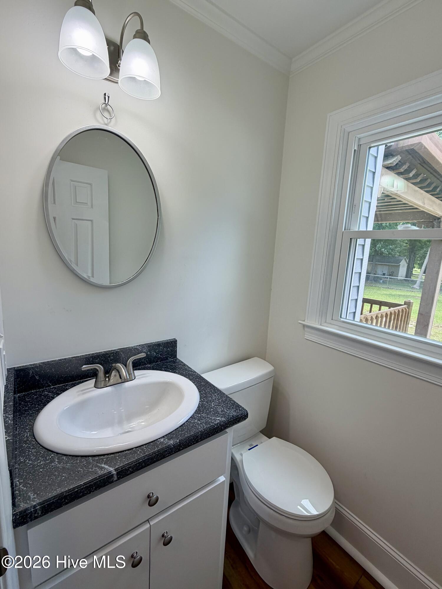 Half bathroom located just off the kitchen features a new vanity, new countertops, new flooring, new windows!