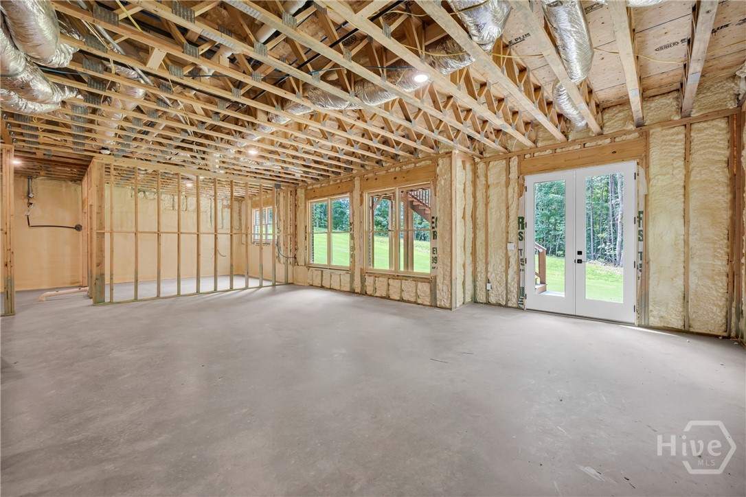 Unfinished basement space featuring exposed wood framing, concrete flooring, and recessed ceiling lighting