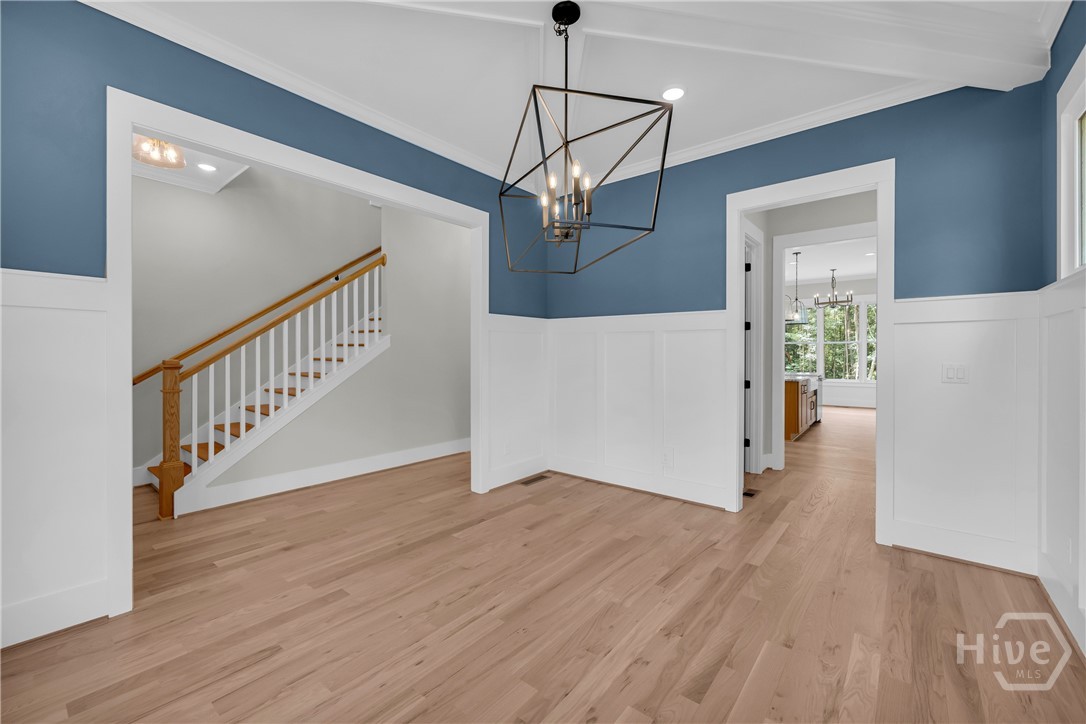 Hardwood flooring complements the wainscoting and blue walls in the beautiful Dining Room