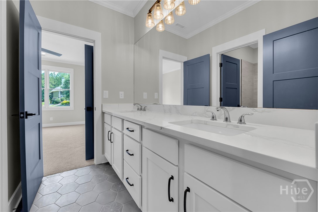 Spacious bathroom featuring a dual vanity with white cabinetry, polished chrome fixtures, and a large mirror