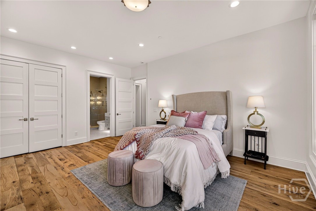 Bedroom #2 offers a spacious layout with wide-plank flooring, recessed lighting, and direct access to a private ensuite. Symmetrical wall placement and dual doorways enhance flow, while the open sightline to the bath underscores the suite’s privacy and convenience. A well-appointed retreat ideal for guests or extended stays.