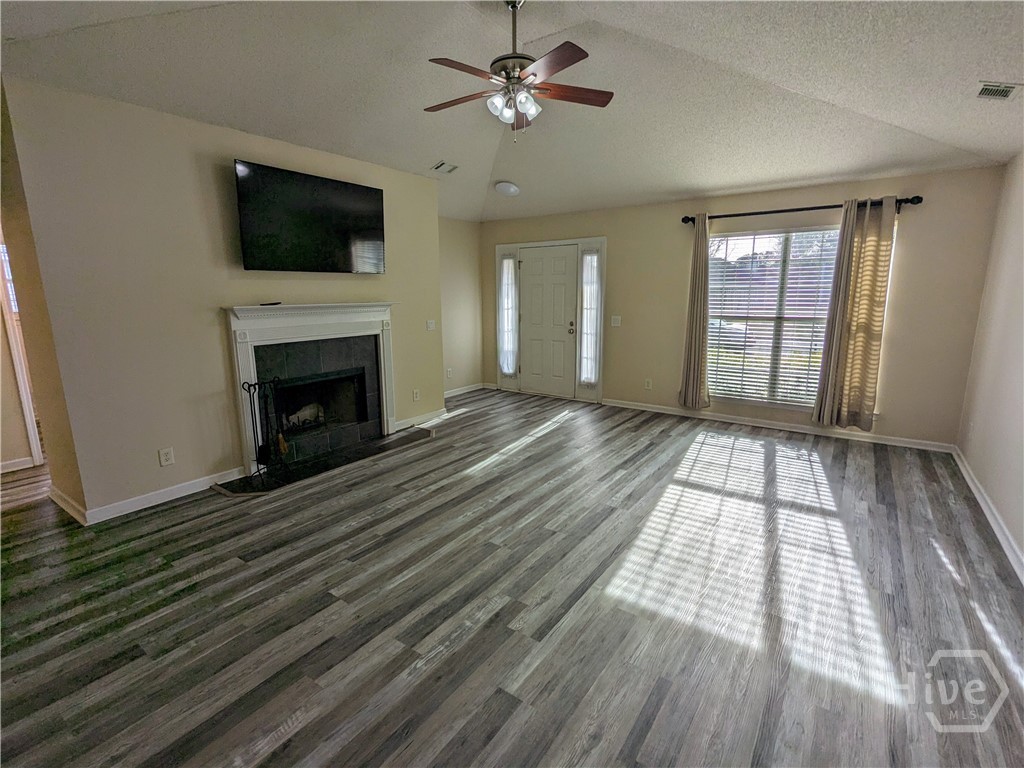Greatroom with wood burning fireplace. View from dining area.