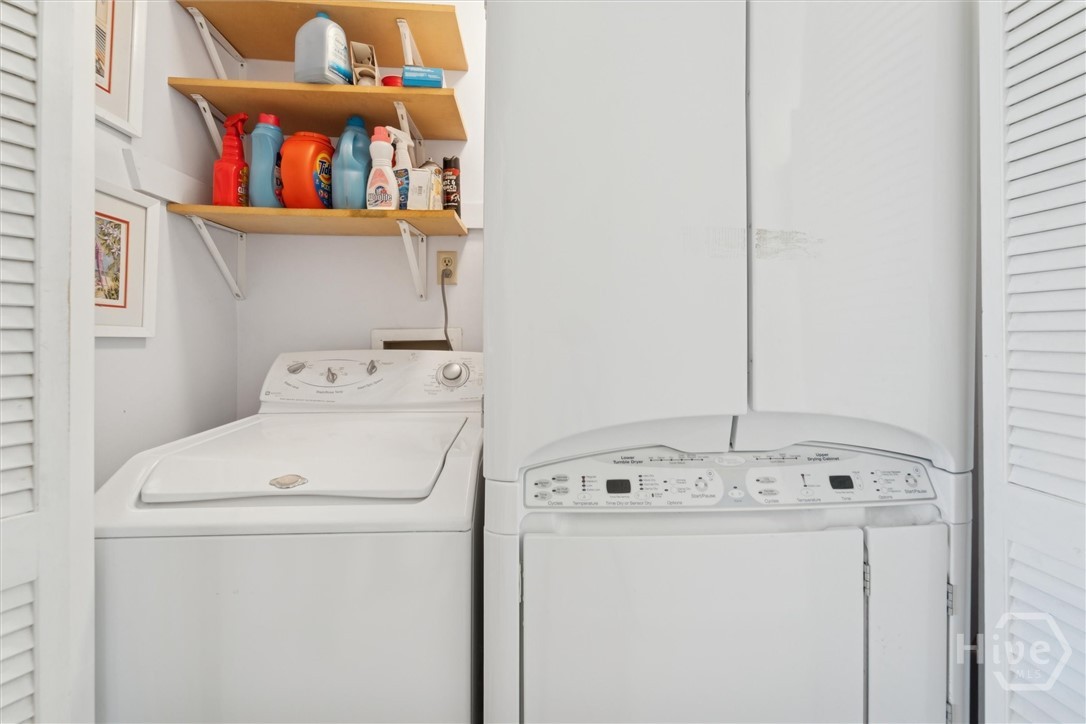 In the hallway between both bedrooms is the laundry room.  Washer,  dryer and steamer remain with the unit.
