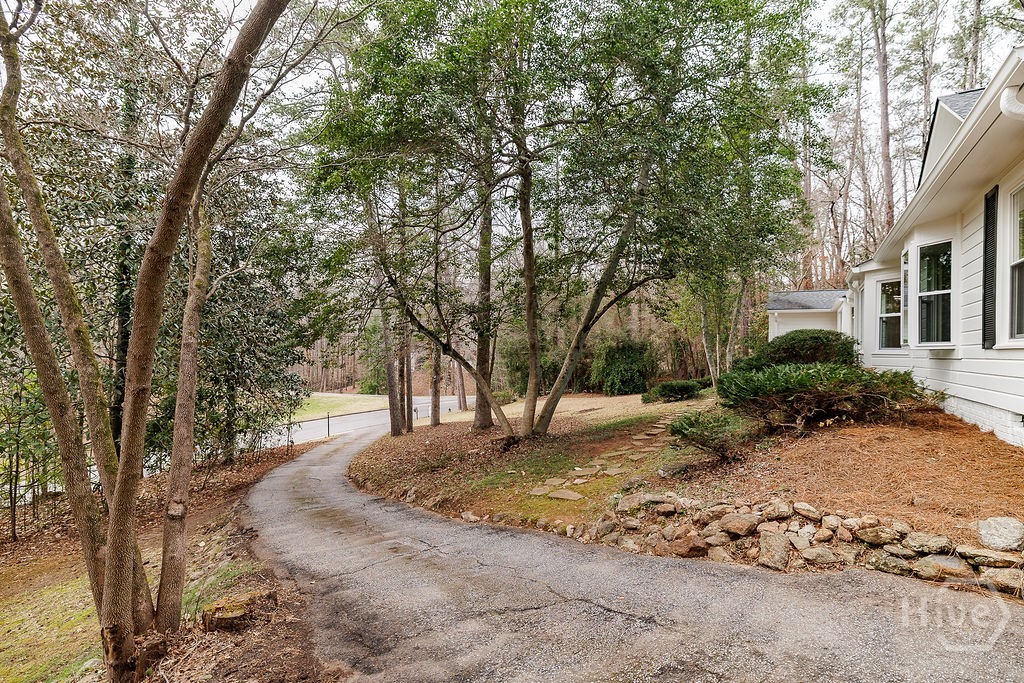 The trees, winding drive, and natural setting feel