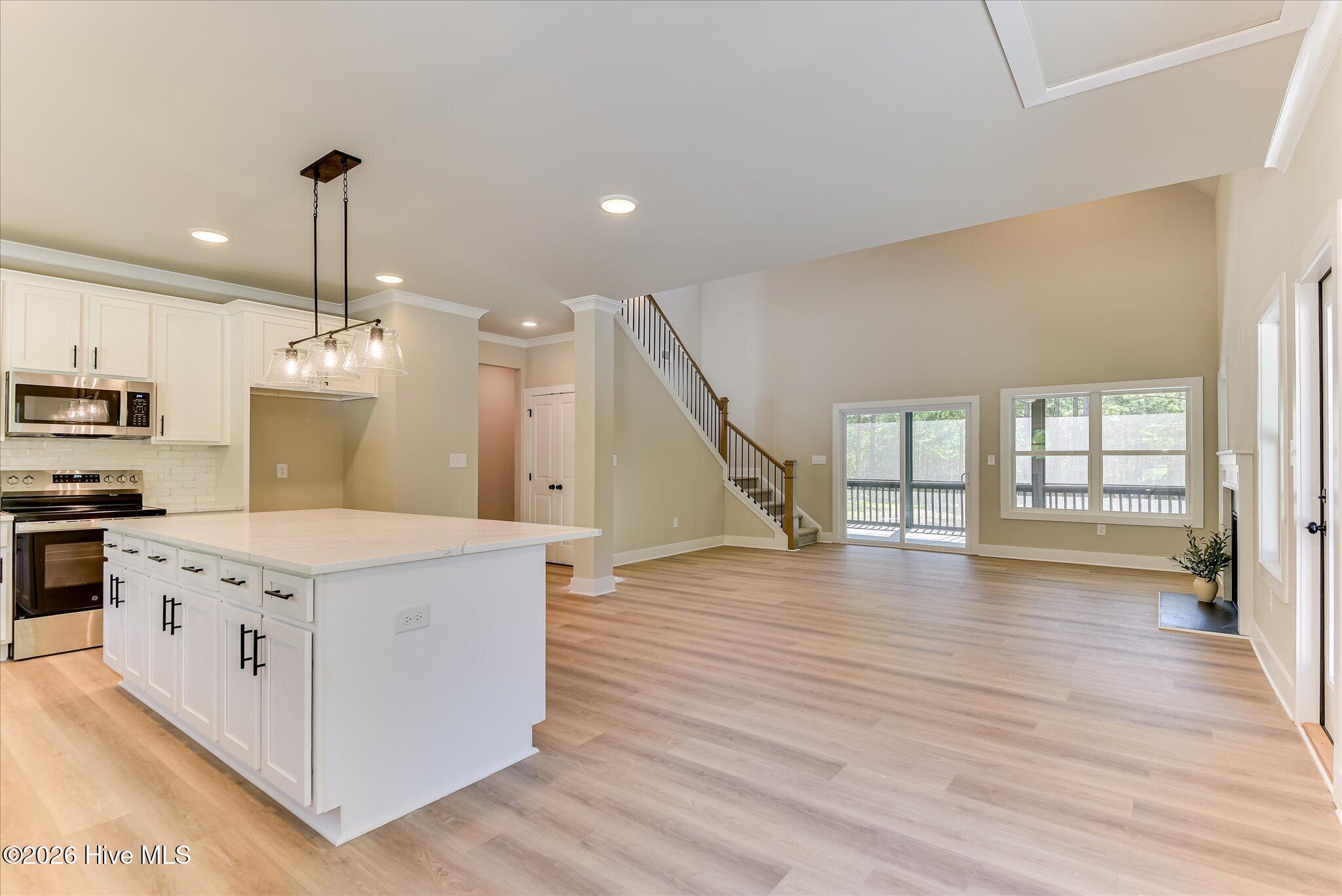 Open floor plan, an abundance of natural light, electric fireplace, vaulted ceiling, sliding doors to the screened rear porch.