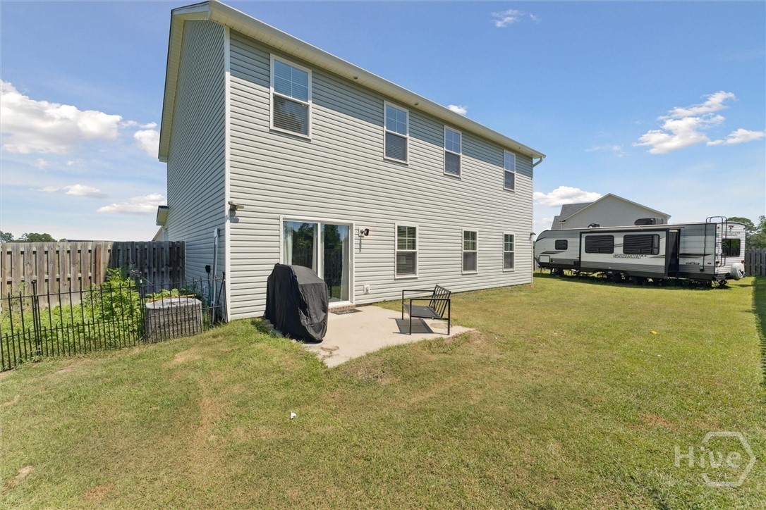 Back patio, huge yard, and small garden to left of