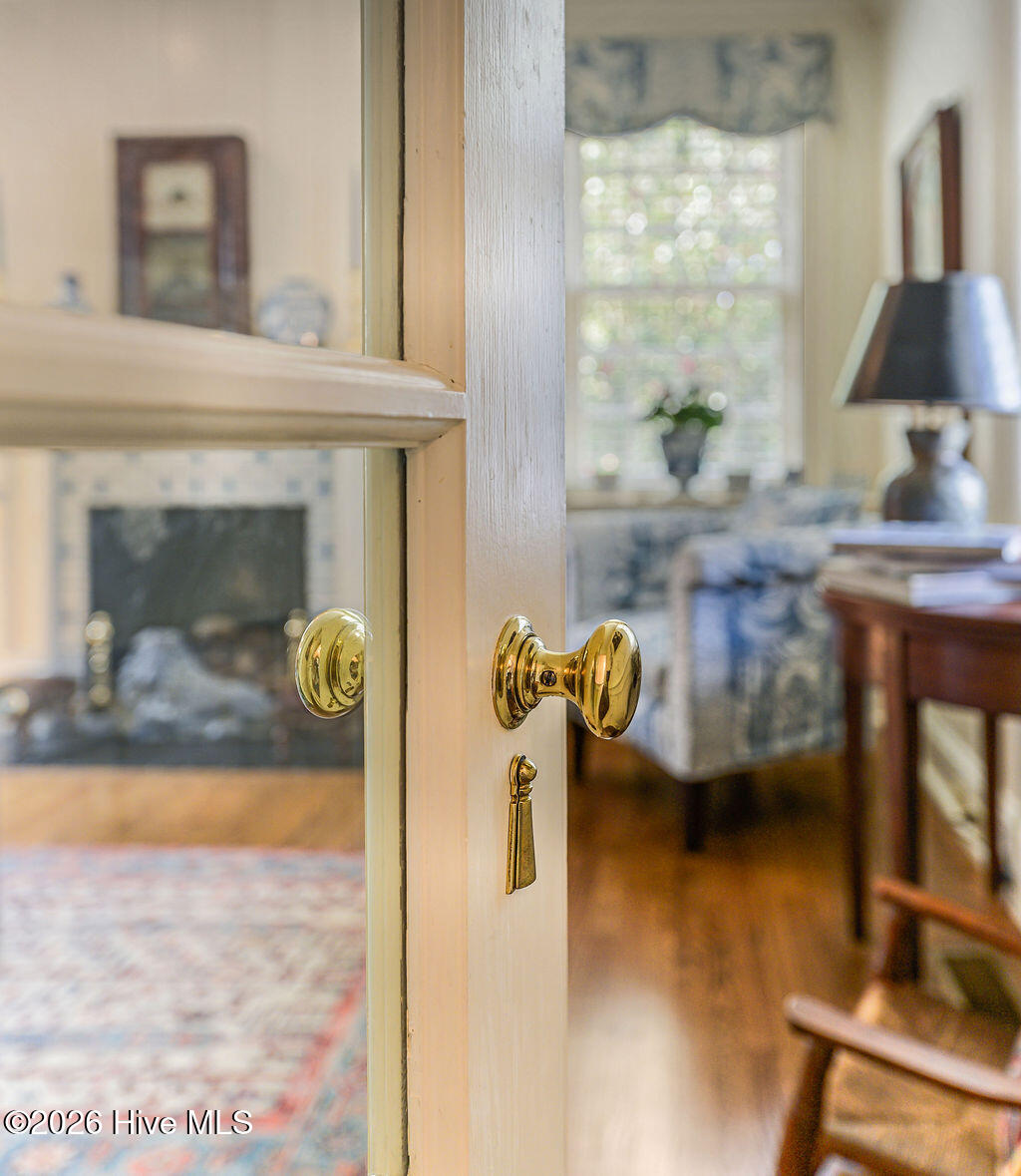 Glass panel solid-wood doors with brass key plates leads to sitting room