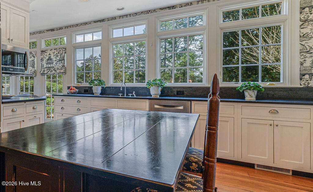The kitchen was fully redesigned in the
1999-2001 restoration. Reclaimed heart-
pine floors -- the only room in the house
with heart-pine, chosen intentionally. Every
other room retains its original 1916 solid
oak. The kitchen connects directly to the
grounds and garden.