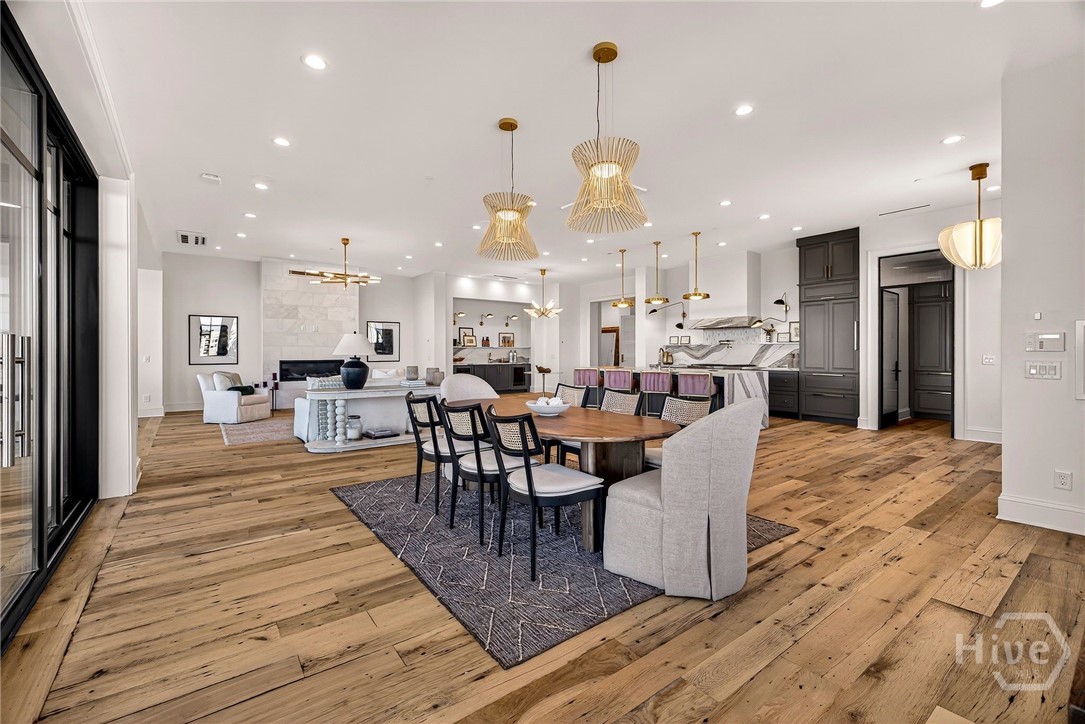 Open-concept kitchen, dining, and living area. A grand open-concept layout seamlessly integrates kitchen, dining, and living zones with architectural cohesion. Wide-plank flooring and sculptural lighting define each area, while the central island anchors the space for both culinary and social use. Designed for luxurious entertaining and effortless daily living.