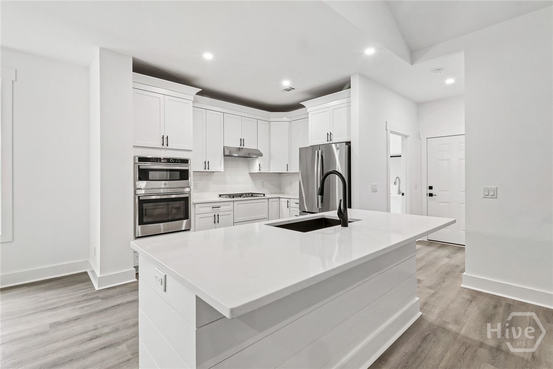 The gourmet kitchen includes a gas cooktop, microwave/double oven combination, soft-close cabinetry, quartz counter tops.