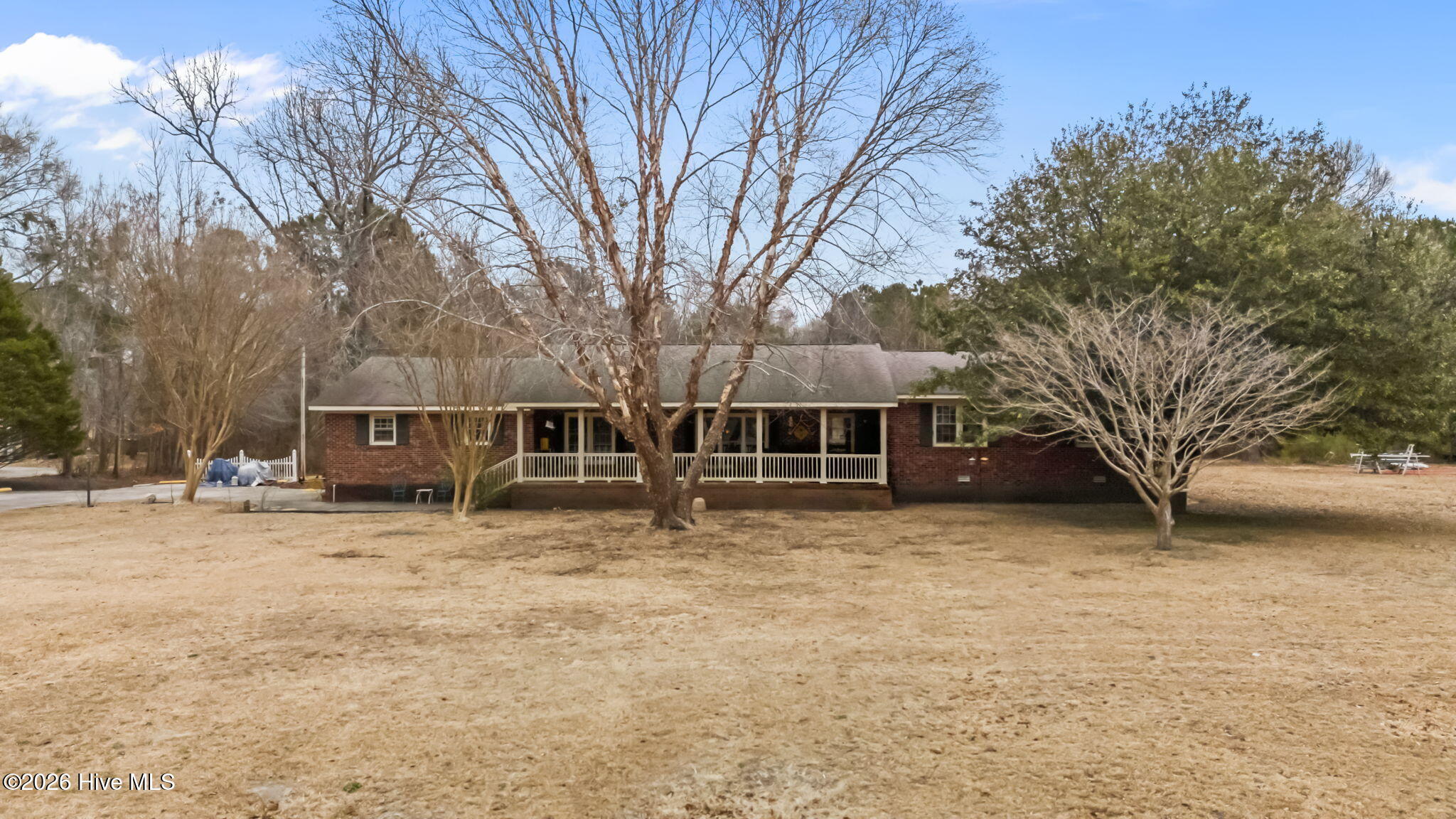 A lovely, rambling brick residence, unrestricted by deed or zoning with 4.8 acres of land near Minnesott Beach! This is a totally unique property, offering genteel living possibilities, along with subdivision and commercial potential. Located on Rt. 306 on the way to the ferry (making this convenient as a commuter base) there is ample road frontage (over 296') and lots of room to develop the estate of your dreams! The 3-bedroom residence is set comfortably back from the road and is really a great family home  and lives even larger than its size may suggest, because of the way the floorplan circulates. You first approach the front door across a huge covered front porch (10'9'' x 37'9''). You'll be greeted by a large foyer with the living room straight ahead, the family room/dining kitchen welcoming you and the bedroom wing to the right. The family room is expansive, with wood floors which merges seamlessly with the country kitchen and dining areas. The kitchen has extensive cabinetry and counters with views out to the private acreage. The living room adjoins, also with wood floors and a lovely fireplace which invites cozy winter evenings around the hearth. The bedrooms are well-proportioned, and the master suite has a private bath w/a new vanity. The utility room off the kitchen leads to the two-car garage and a fantastic, private screened porch overlooking your quiet backyard. Out back is a large garage/workshop with a second floor, which seems perfect for a workshop or possible home-based business... There's so much to see and appreciate here, the home is a great value & priced to accommodate some needed improvements and upfits...It's ready for your final finishing touches. The acreage assures privacy and flexibility so to allow you room to spread out and make your dreams a reality! Have you ever considered a mini-farm, or raising horses?   Here's your perfect investment opportunity!