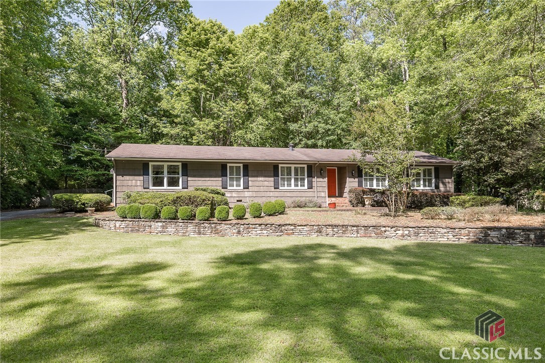 Welcome to 145 Rollingwood Drive, a charming single-story ranch located in desirable Cedar Creek, minutes to east side shopping and downtown Athens. This unique home boasts a spacious floor plan, perfect for entertaining and relaxing with family and friends.As you step inside, you'll notice the newly installed LVP flooring and hardwoods throughout the home, replacing all carpet. The home features a formal living room and dining room with built-in cabinets, perfect for displaying your favorite items. The rear of the home offers a bright and airy eat-in kitchen and den space, complete with sun soaked windows overlooking the backyard. The kitchen has updated cabinetry and granite countertops, while a large laundry/storage room is conveniently located off the kitchen.The converted garage/bonus room with built-ins and plantation shutters provides an additional 400 square feet of living space. On the opposite end of the home, you'll find two secondary bedrooms and two guest bathrooms. The primary suite, located at the rear of the home, includes ample storage and a luxurious ensuite bathroom with a separate, tiled shower and garden tub.Step outside to enjoy the serene backyard, featuring mature plants and trees, a fenced-in backyard with a koi pond, patio space, and brand new decking accessible from the primary suite, eat-in kitchen, and den. 145 Rollingwood Drive is zoned for the upcoming Maxine P. Easom Elementary. This gives you the option, currently, to select from several excellent elementary schools including Whit Davis, Gaines School Road, or Barnett Shoals. Cedar Creek offers a non-mandatory membership to the Cedar Creek Civic Association for $45 per year and a voluntary pool membership for $375 per Season. Don't miss your chance to call this one-of-a-kind home yours!