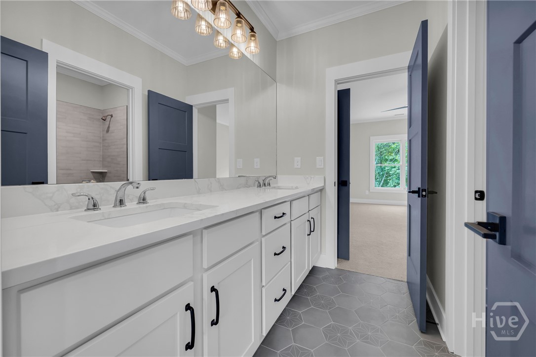 Dual vanity with white cabinetry, integrated sinks, chrome faucets, and a full-width mirror