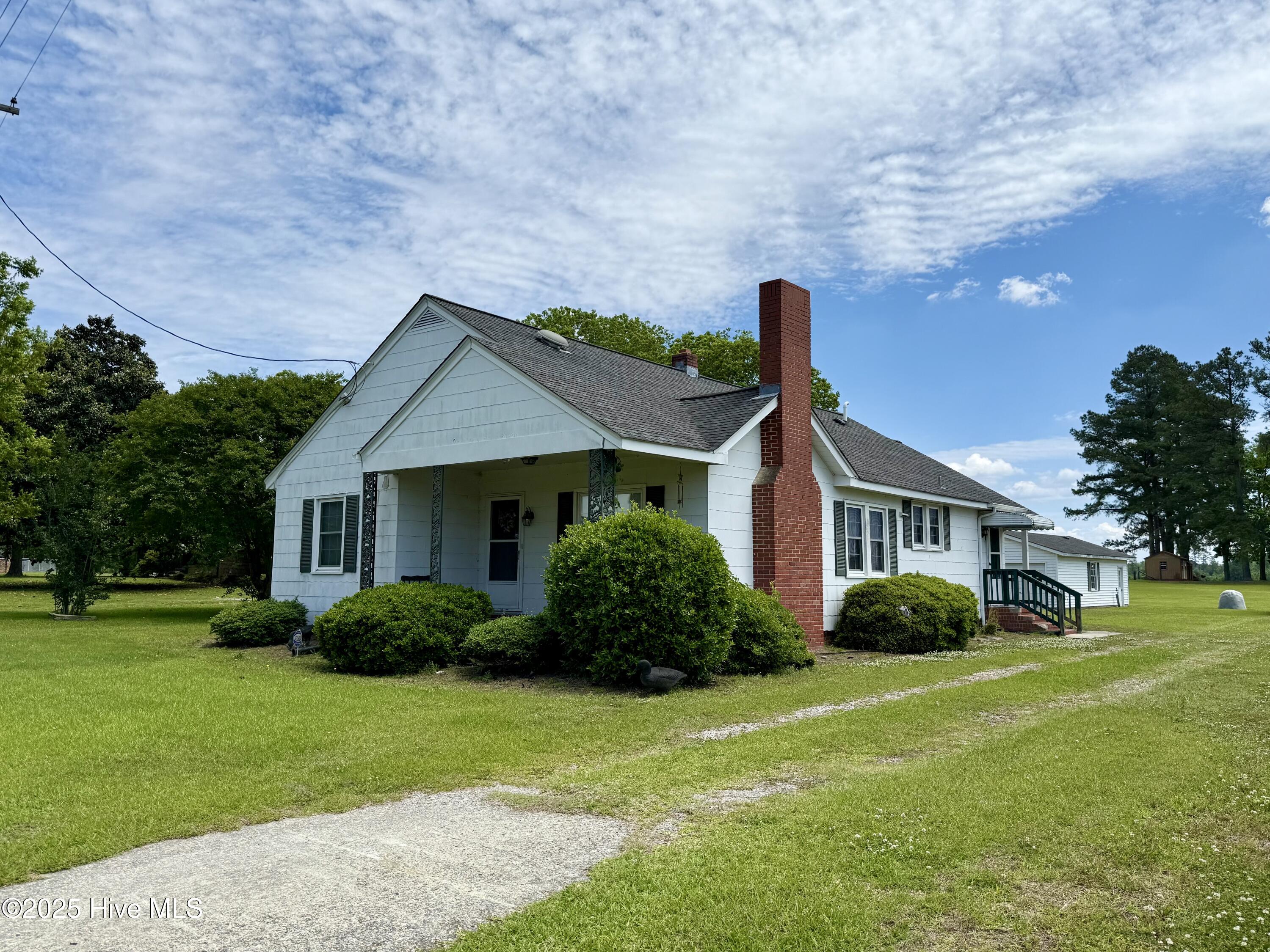 Experience the charm of this newly listed 3-bedroom, 2-bathroom home, nestled on nearly half an acre just outside the picturesque town of Bear Grass. From the moment you step inside, you'll be greeted by a cozy, inviting atmosphere that feels like home. The heart of the house lies in the spacious, open dining and kitchen area, thoughtfully designed for both functionality and style. A convenient eat-at bar separates the dining space from the U-shaped kitchen, which is perfectly equipped to inspire any home cook. Nearby, the living room exudes warmth with its brick fireplace, offering the ideal spot for gas logs to create a comforting, welcoming ambiance. The home's layout is both practical and inviting. The two guest bedrooms, equal in size, are located on either side of the shared guest bathroom. This bathroom combines retro appeal with modern features, including tiled flooring, a pedestal vanity, and a tub-shower combination. At the rear of the home, the master suite offers a private retreat, complete with an en-suite bathroom featuring a step-in shower and double closets for ample storage. Additional conveniences abound, such as a dedicated laundry area and a private covered back porch, with both easily accessible from the master suite. Stepping outside, you'll find a spacious 36' x 20' detached garage—perfect for storage, a workshop, or a personal retreat. Inside the home, storage is plentiful with a large kitchen pantry and multiple hallway closets. Modern amenities such as central propane heating and air conditioning provide year-round comfort, while the home's well water system helps keep utility costs low. This delightful property seamlessly blends practicality, comfort, and charm, offering a wonderful opportunity to make it your own. Don't miss out on this one-of-a-kind home!
Please note: The home features asbestos-shingled siding. While this material is durable and commonly used in older homes, proper precautions should be taken during any renovations.