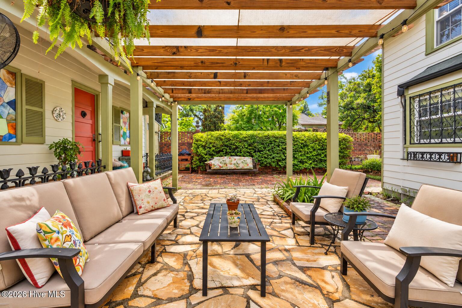 Courtyard with historic bricks and tall walls for privacy. and a shaded trellis for backyard entertaining